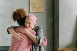 woman with cancer hugging another woman