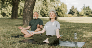 elderly couple meditating outside