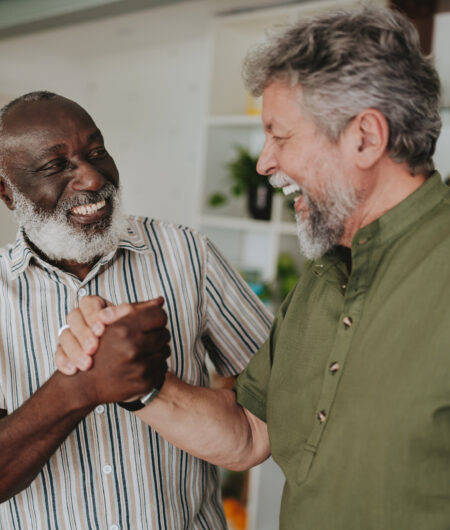 Portrait of two senior friends talking at home