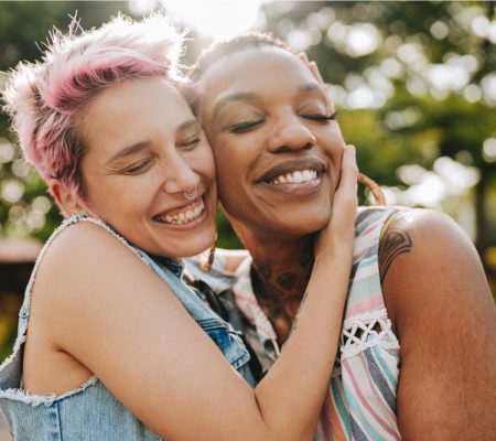 Two women embracing, cheek to cheek.